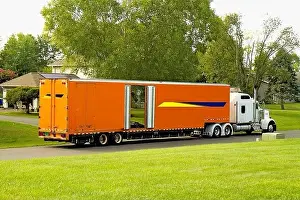 Transporter Prints: Large Orange Moving Truck out front of a neighborhood home while loading the owner's household item