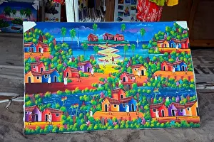 Dominican Republic Prints: A large painting shows colourful houses and palm trees in a Caribbean landscape