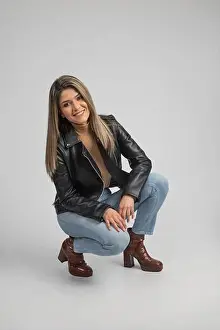 Happines Prints: Latin woman squatting with a casual outfit that have black leather jacket