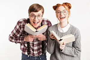 Female Friends Prints: Laughing couple of school nerds holding books isolated over white background
