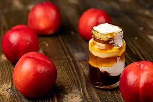 Calcium Prints: layered yogurt with jam and pieces of ripe nectarine, yogurt in a glass jar with fruits