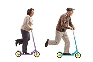 Full Body Prints: Full length profile shot of an elderly woman and an elderly man riding scooters isolated on white background