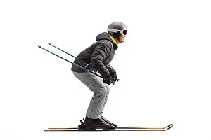 Full length profile shot of a man skiing isolated on a white background