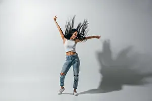 Looking Away Prints: full length view of girl dancing with hands in air on white background