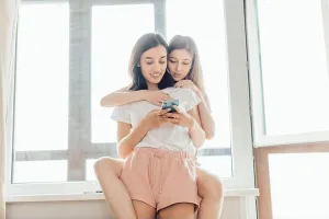 Receiving Prints: two lesbians chatting with friends online, doing shopping indoors, close up photo
