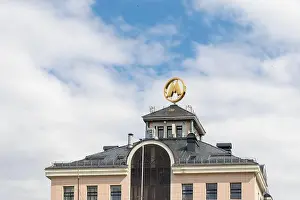 Signboard Prints: The letter 'M' is the logo and symbol on the roof of the building against the sky