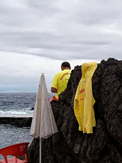 Ocean Breeze Prints: A lifeguard sits on a volcanic boulder