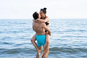 Young Family Prints: Lifting Woman At Beach At Sea In Summer