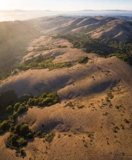 Aerial Landscape Collection: The last light of day illuminates San Francisco Bay Area and the golden East Bay hills