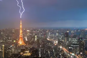 Lightning storm over Tokyo city, Japan in night with thunderbolt over Tokyo tower. Thunderstorm in Tokyo, Japan