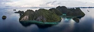 Aerial Landscape Collection: Limestone islands in Raja Ampat, Indonesia, are surrounded by healthy coral reefs