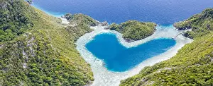 Limestone islands surround a uniquely shaped lagoon in Raja Ampat, Indonesia. This remote, tropical region is known for its marine biodiversity