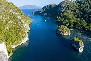 Limestone islands are surrounded by healthy coral reefs in Raja Ampat, Indonesia. This region is thought to be the epicenter of marine bodiversity