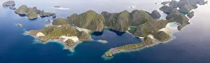 Limestone islands are surrounded by healthy coral reefs in Raja Ampat, Indonesia. This region is thought to be the center of marine biodiversity