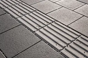 Disability Prints: Line of hazard warning tactile paving along the edge of platform at the train station
