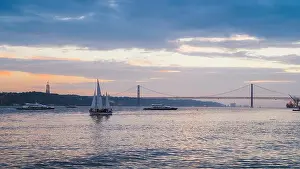 Lisbon, Portugal - Oct 23, 2018: Sunset on River Tagus, Lisbon, Portugal with 25 April Bridge in background and boats