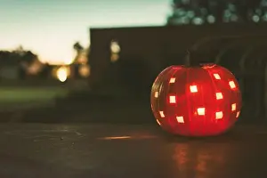 Flicker Prints: A lit jack o lantern sitting on a porch near dark on an autumn evening