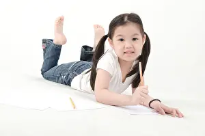 Ponytail Prints: Little Asian girl drawing, lying on floor