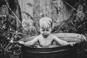 Bathtub Prints: a little boy bathes in a basin in the summer in a green garden