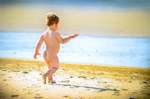 Playtime Prints: Little boy walks confidently free on the beach