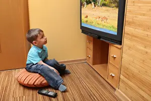 Childish Prints: Little boy watching cinema on TV