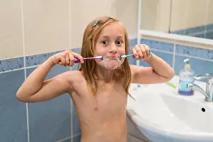Toothbrush Prints: Little girl brushes teeth with two brushes. Stomatology. oral health care