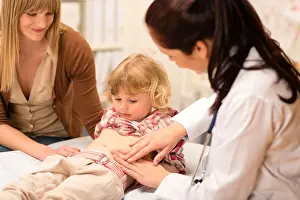 Sore Prints: Little girl having tummy examination by pediatrician at medical office