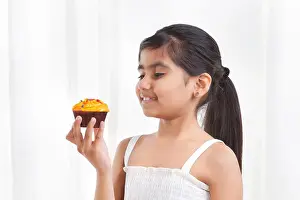 Young Girl Prints: Little girl holding a cupcake