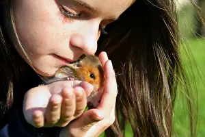 Little girl kissing a hamster