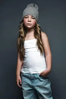 Curls Prints: Little girl model professionally posing in the studio in jeans and a white T-shirt