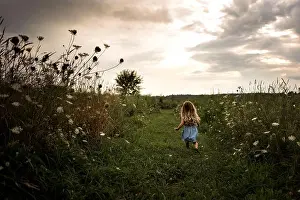 Preteen Prints: Little girl running through flowers in a field at sunset