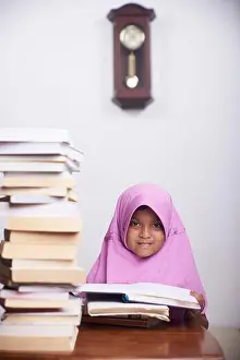 Love Emotion Prints: Little muslim girl in hijab reading a book and study at home