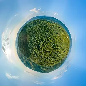 Little planet globe with dark mountain hills covered with green mixed pine