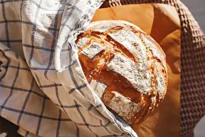 Checkered Prints: A loaf of golden, rustic bread is freshly baked and wrapped in a checkered cloth