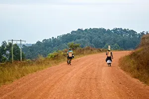Dirt Road Prints: Local women walking on a red earth dirt road in rural Africa