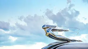Hood Prints: Locomotive 1940s Chevrolet hood ornament seen from below with sky and clouds in the background