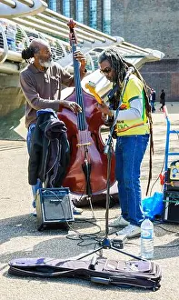 Braids Prints: LONDON, ENGLAND, UK - MAY 4, 2014: Two street musicians play music near Tate Modern gallery