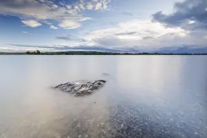 Lonesome Prints: A lonely rock in the lake under a slightly cloudy sky