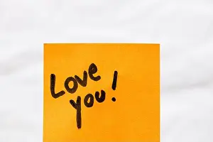 Notepaper Prints: Love you handwriting text close up isolated on orange paper with copy space