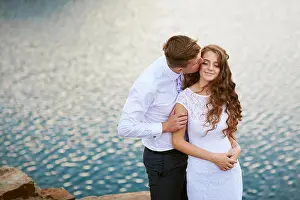 Flower Garden Prints: loving bride and groom walking on a background of lake