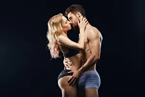 two loving people having sex. close up side view photo. isolated black background.desire concept
