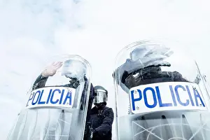 Unrecognizable Prints: Low angle of anonymous police soldiers in protective uniforms and helmets standing against squad van