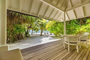Images Dated 4th January 2017: Luxury beach villa, backyard deck with chairs and table. Relaxing beach scene, palm trees