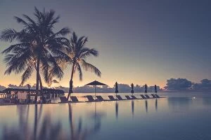 Images Dated 12th December 2015: Luxury infinity beach pool in sunset time. Palm trees and calm weather on the beach