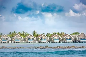 Island Beach Prints: Luxury vacation in Maldives with water bungalows and palm trees background on tropical island