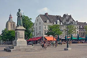 Flames Prints: Maastricht market square group of women cyclists all wearing large scout emblems on tee shirt uniforms statue of