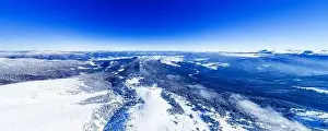 Magical panorama of a beautiful hill in the mountains covered by snow on the ski slope on a sunny day with a clear blue