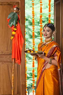 Worshiping Prints: Maharashtrian woman in traditional dress celebrating gudi padwa festival holding a pooja plate looking at camera