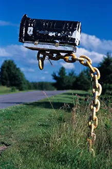 Postbox Prints: Mailbox on a chain with 'Welcome' inscription along a country road in Prince Edward Island