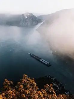 Serbian Prints: Majestic Foggy autumn landscape with cargo ship on water at sunrise